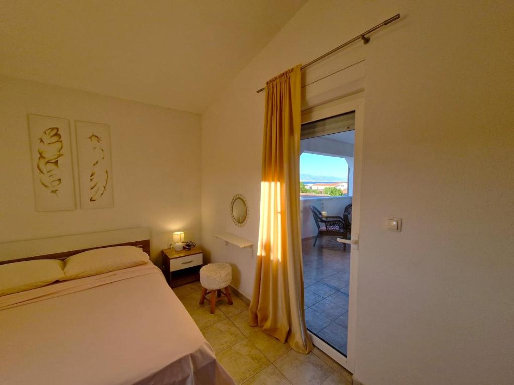 a bedroom with a bed and a door to a balcony at Apartments Rosa Soldatica in Vir