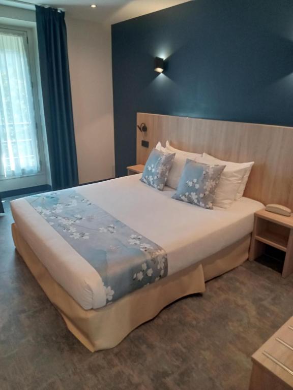 a bedroom with a large bed with blue walls at Hotel Modern Est in Paris
