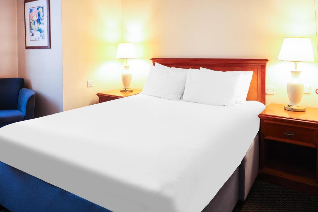 Postel nebo postele na pokoji v ubytování OYO Tong Park Hotel