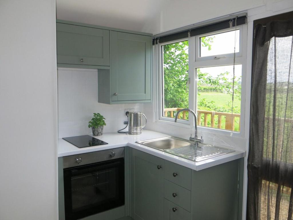 une cuisine avec un évier et une fenêtre dans l'établissement The Garret Studio Apartment,Balcony views & Parking, à Topsham