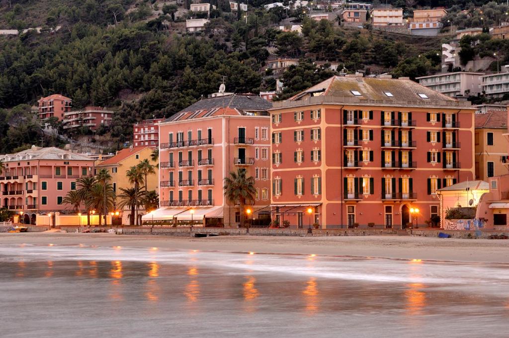 a group of buildings next to a body of water at Hotel Residence Baiadelsole in Laigueglia