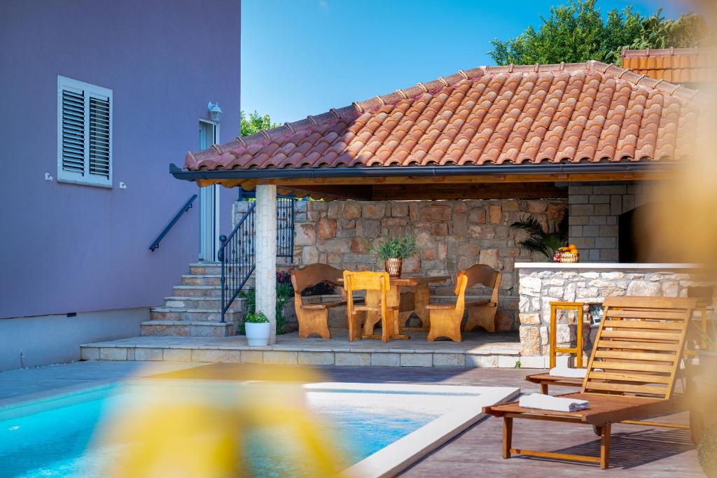 a gazebo with a table and chairs next to a pool at Villa Silente in Oklaj