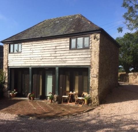 una casa de ladrillo con una mesa delante en Devon Country Retreat The Linhay at Collaton Farm, en Newton Ferrers