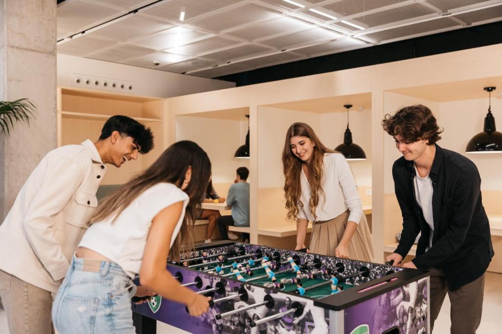 a group of people standing around a table playing chess at NEW OPENING 2025 aparto Florence Manifattura in Florence