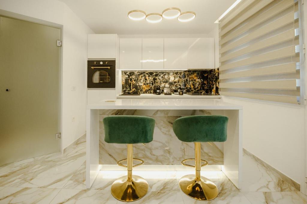 a kitchen with two green bar stools at ΔVO luxury apartment in Agios Nikolaos