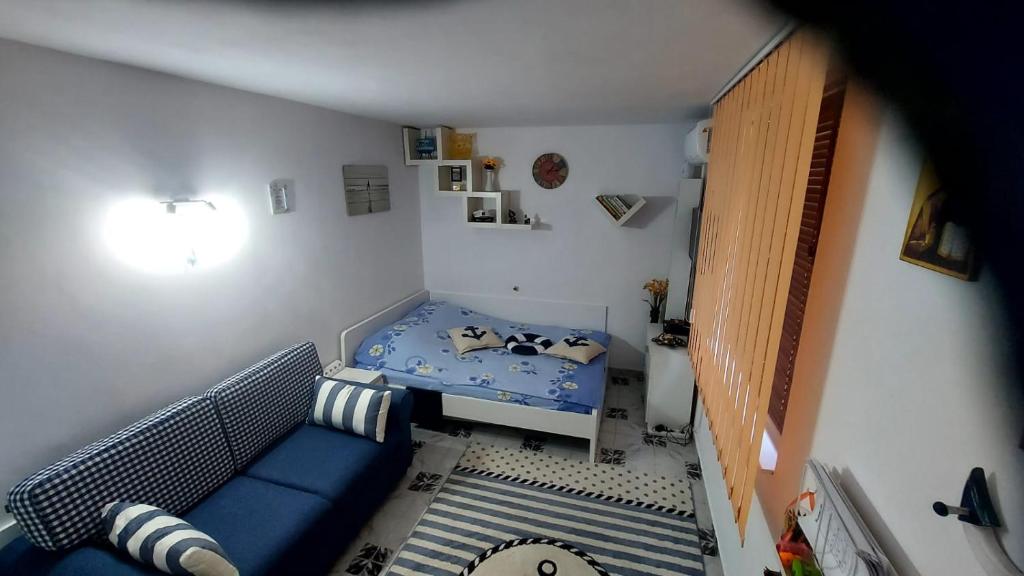 a small room with a blue couch and a bed at Studio Olimp Black Sea in Olimp