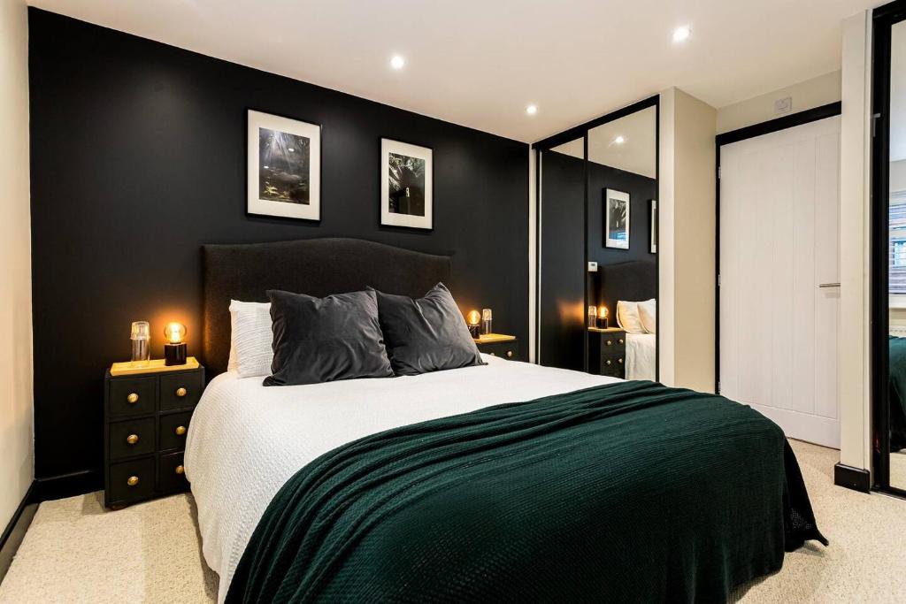 a bedroom with a large bed with black walls at Northern Rest City Retreat in Broadheath