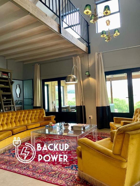 a living room with yellow couches and a table at Underberg - The Burn - Solar Powered in Underberg