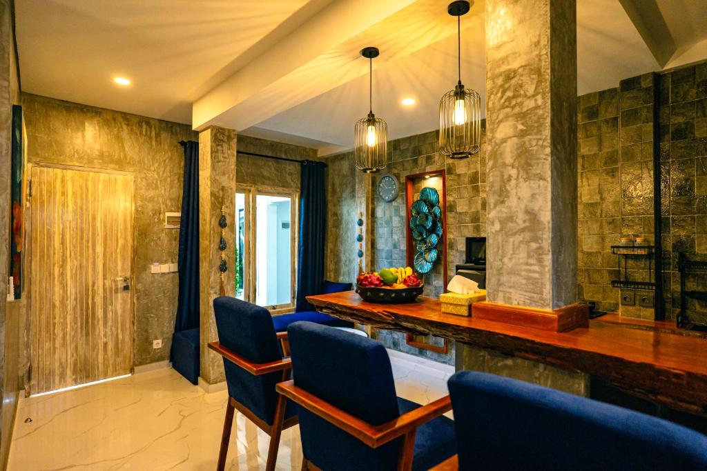 a kitchen with blue chairs and a bar in a room at Amshiga 4 in Jimbaran