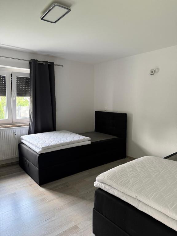 a bedroom with two beds and a window at Schöne EG Wohnung in Kolbermoor