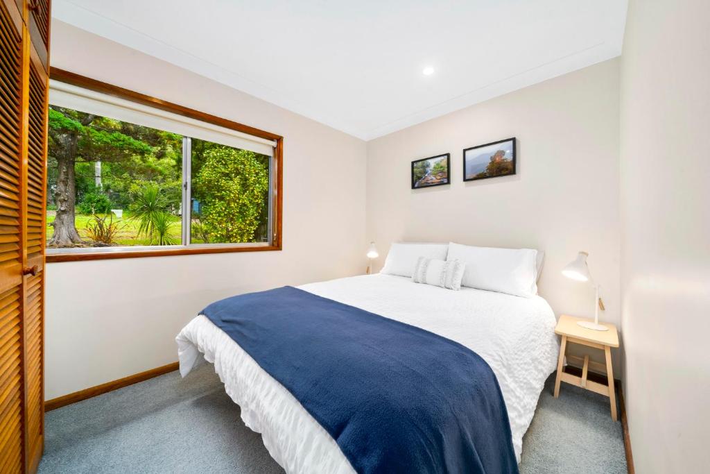 een slaapkamer met een groot bed en een raam bij Godfrey's Cottage in Blackheath