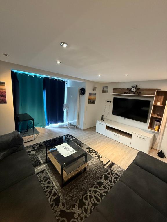 ein Wohnzimmer mit einem großen Flachbildfernseher in der Unterkunft Stilvolle Wohnung im Erdgeschoss in Kolbermoor