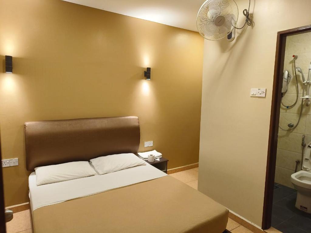 a bedroom with a bed and a bathroom with a shower at The Pines Hotel in Tanah Rata