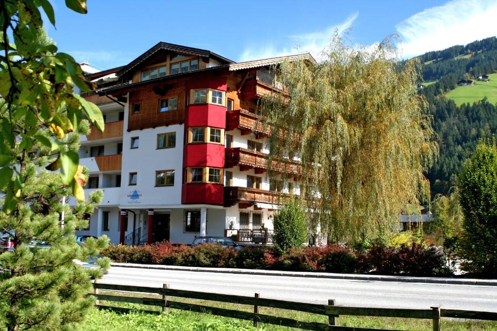 a large building with a tree in front of it at Alpenhotel Ramsauerhof in Ramsau im Zillertal