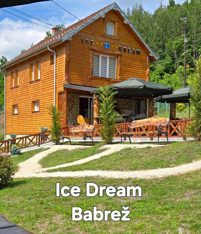 una casa di tronchi con un tavolo e sedie di fronte di STD Ice Dream 