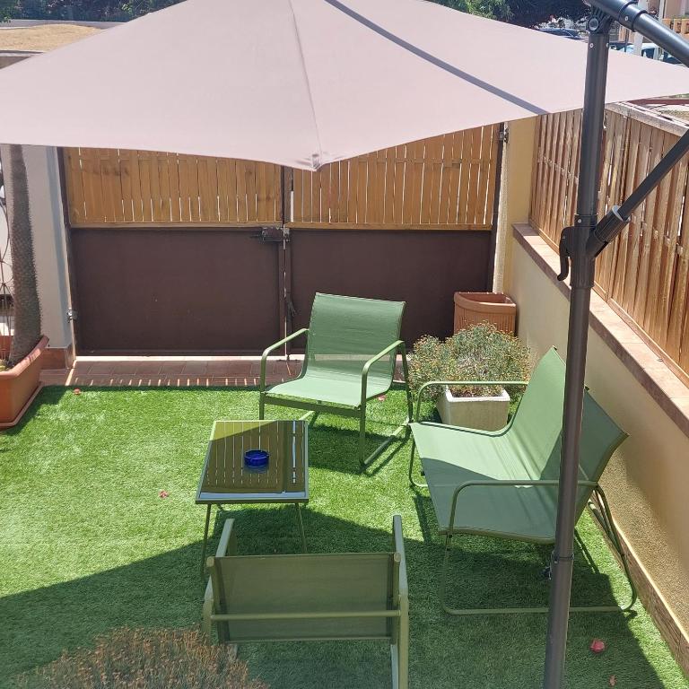 a patio with two chairs and a table and an umbrella at Elmas Room in Elmas