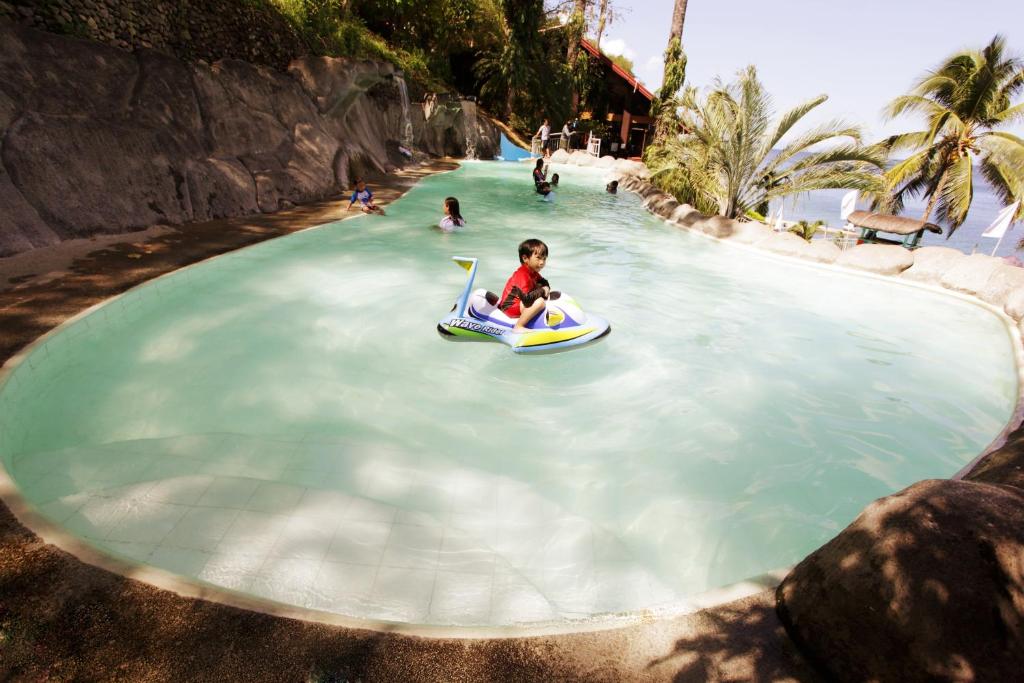 a child riding on a raft in the water at a water park at Eagle Point Beach and Dive Resort in Mabini