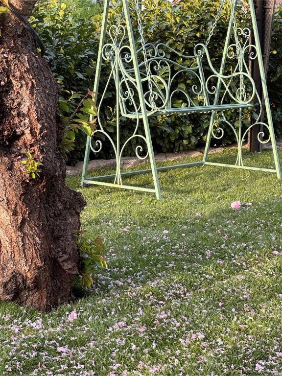 a metal bench sitting in the grass with flowers at Ferienwohnung Landshut am Gambach in Hohenthann