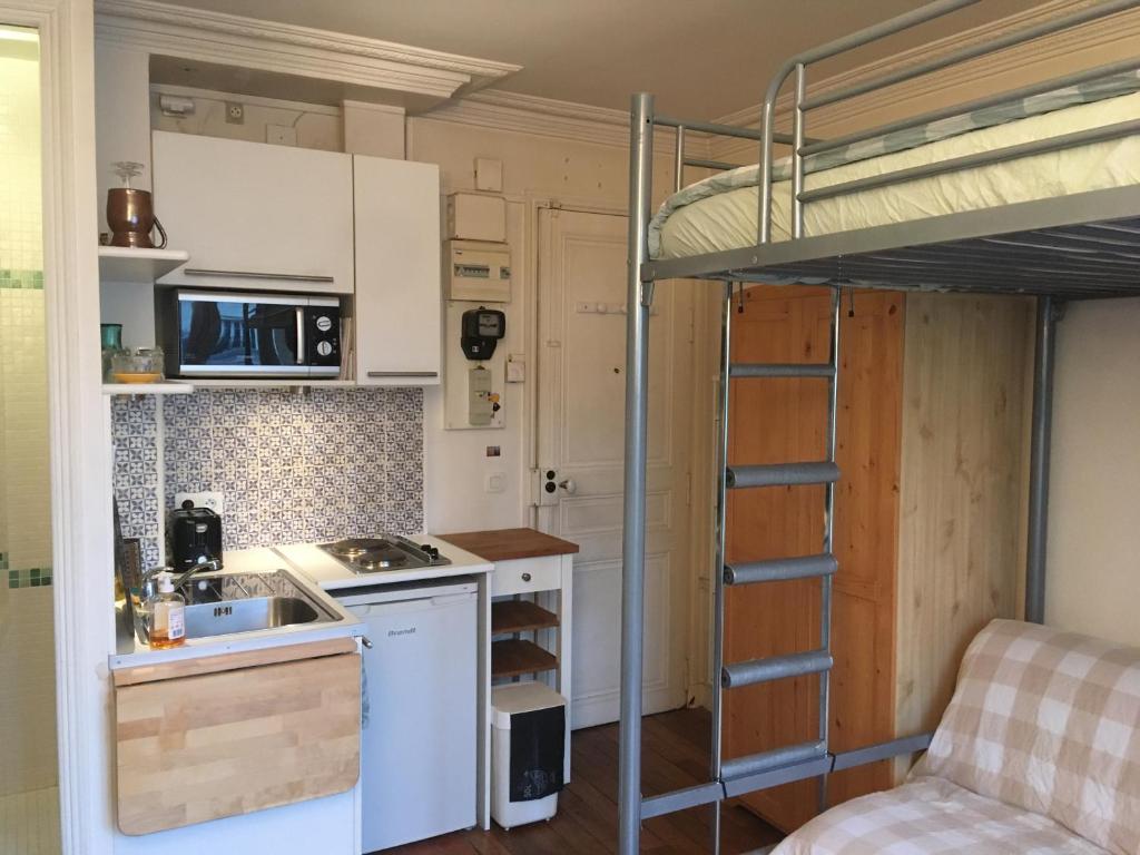 mała kuchnia z łóżkiem piętrowym w pokoju w obiekcie STUDIO 12ième w Paryżu