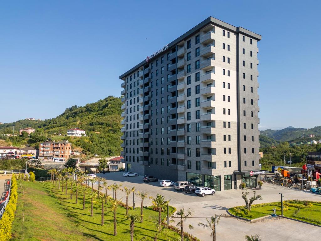 Un edificio alto y blanco con estacionamiento. en Best Western Plus Trabzon, en Trabzon