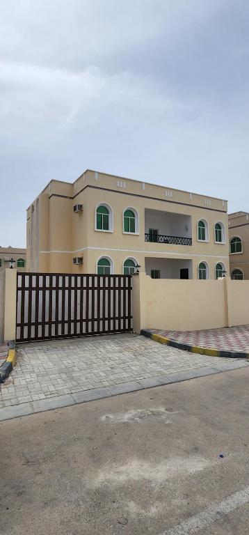 a large building with a fence in front of it at Hasik Beachfront Apartments in Ḩaḑbaram