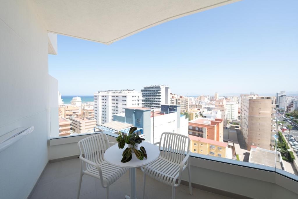 a balcony with a table and chairs and a view of the city at Hotel RH Arena - Todo Incluido in Gandía