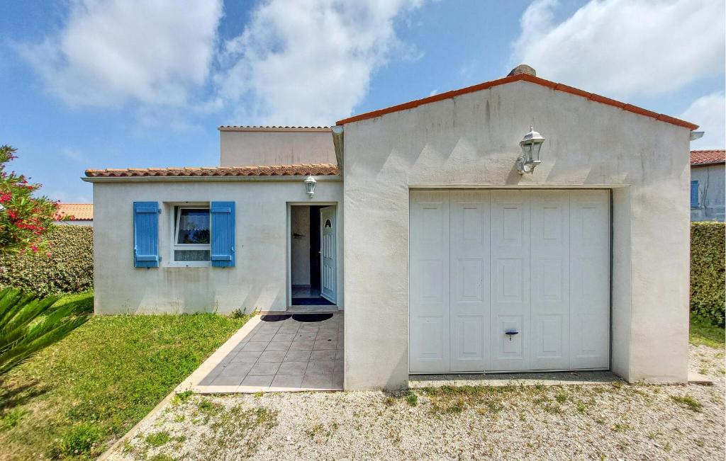 een wit huis met een garage bij Nice Home In Saint-Georges-D'oléron in Saint-Georges-dʼOléron