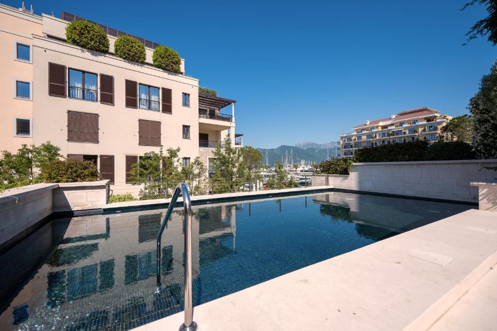 a swimming pool in front of a building at Porto Marina Residence in Tivat