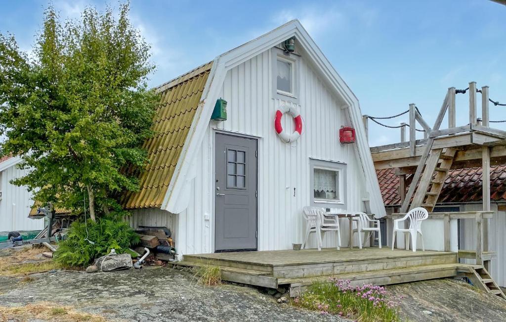 a white building with a porch and a table and chairs at 1 Bedroom Cozy Home In Vrångö in Vrångö
