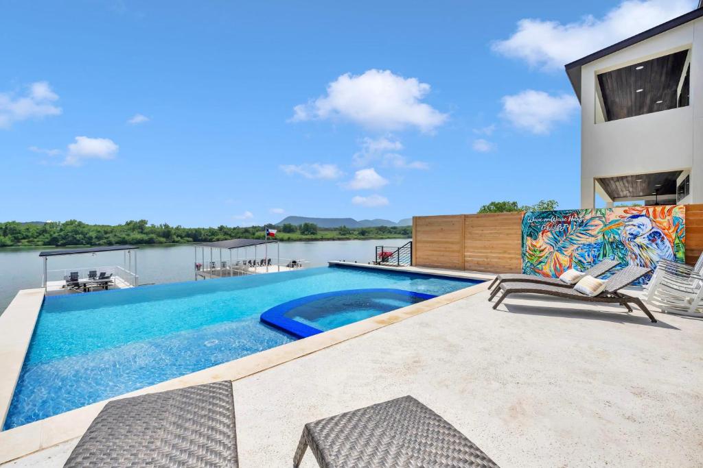 Una piscina con dos sillas en un patio. en Wave on Wave Haus and Concierge Services, en Kingsland