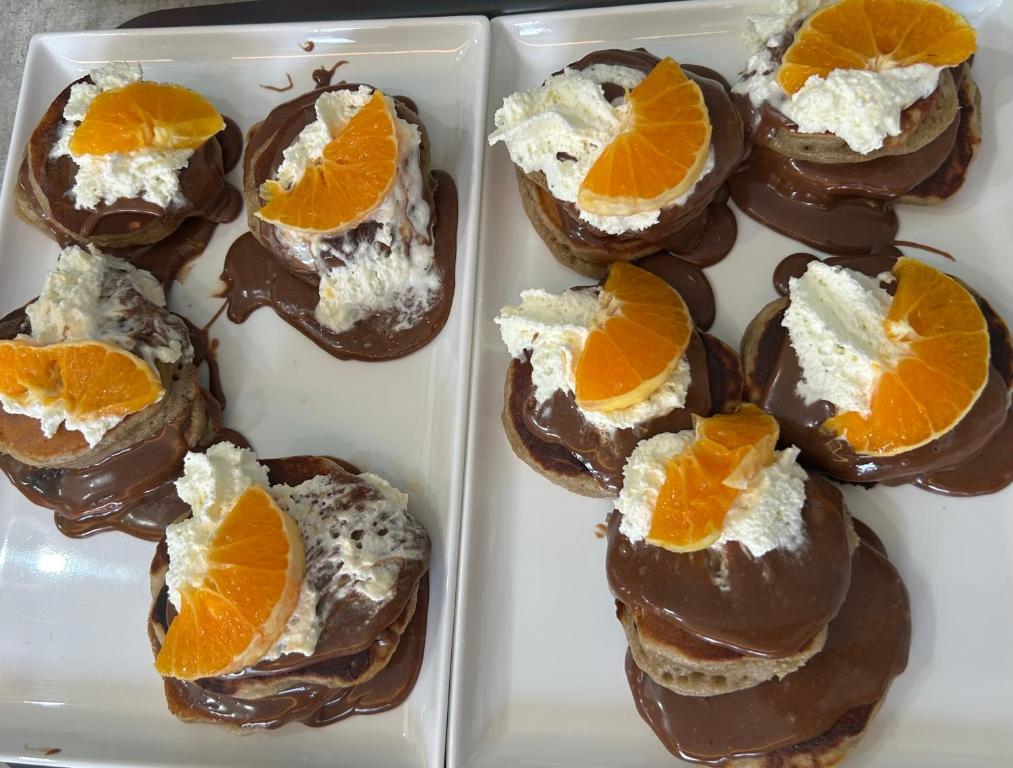 a white container filled with chocolate covered desserts with orange slices at Aliston Hotel Thassos in Skala Potamias