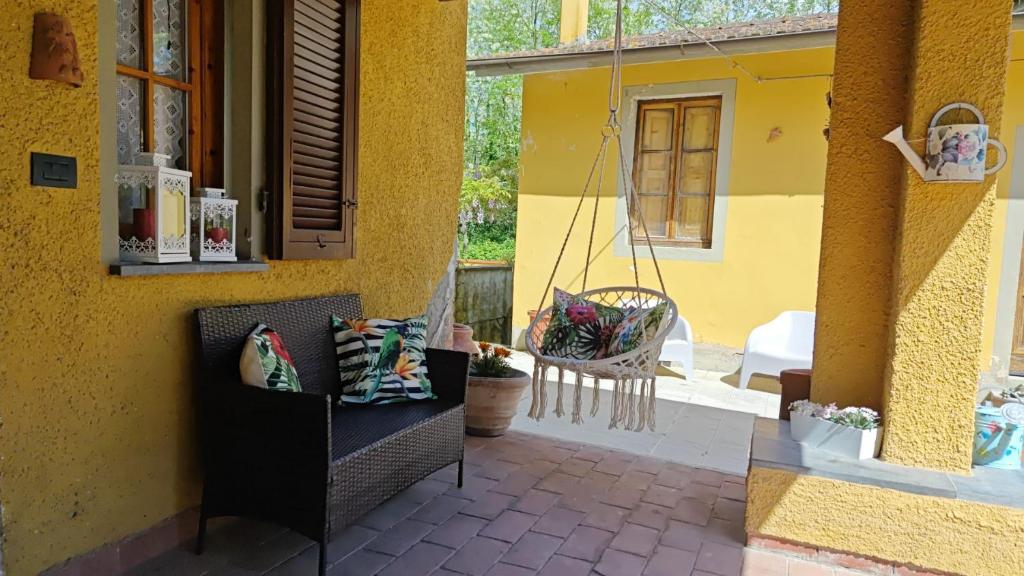 a yellow house with a bench on a patio at Casa Magnolia in Bientina