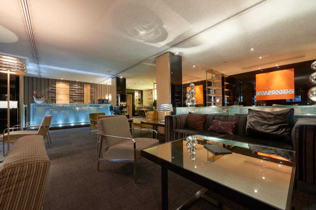 vestíbulo con sofá, mesas y bar en Eurostars Monte Real, en Madrid