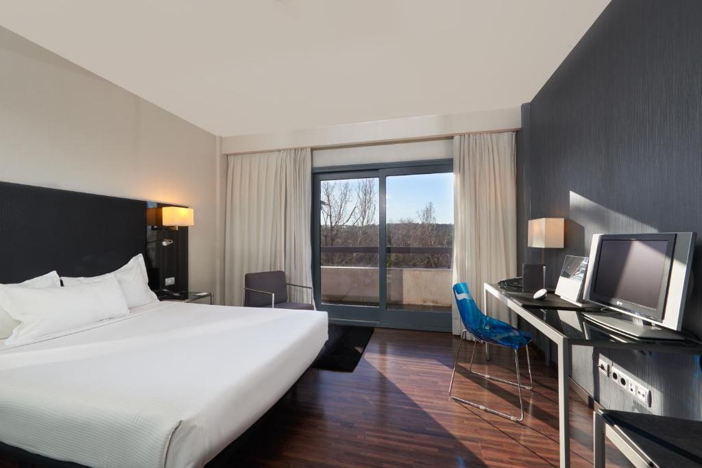 Habitación de hotel con cama grande y TV en Eurostars Monte Real, en Madrid