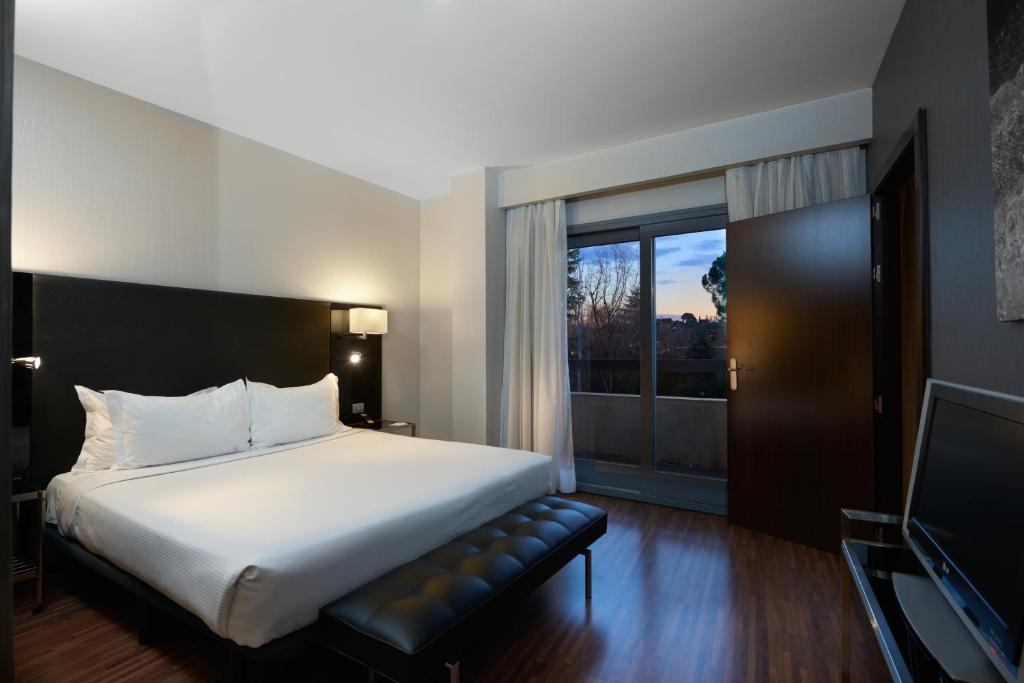pokój hotelowy z łóżkiem i telewizorem w obiekcie Eurostars Monte Real w Madrycie