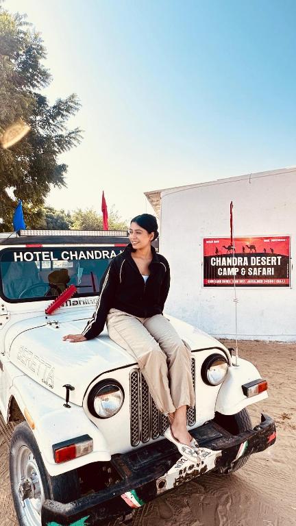 a woman sitting on the hood of a bus at Chandra Safari Hotel Jaisalmer in Jaisalmer