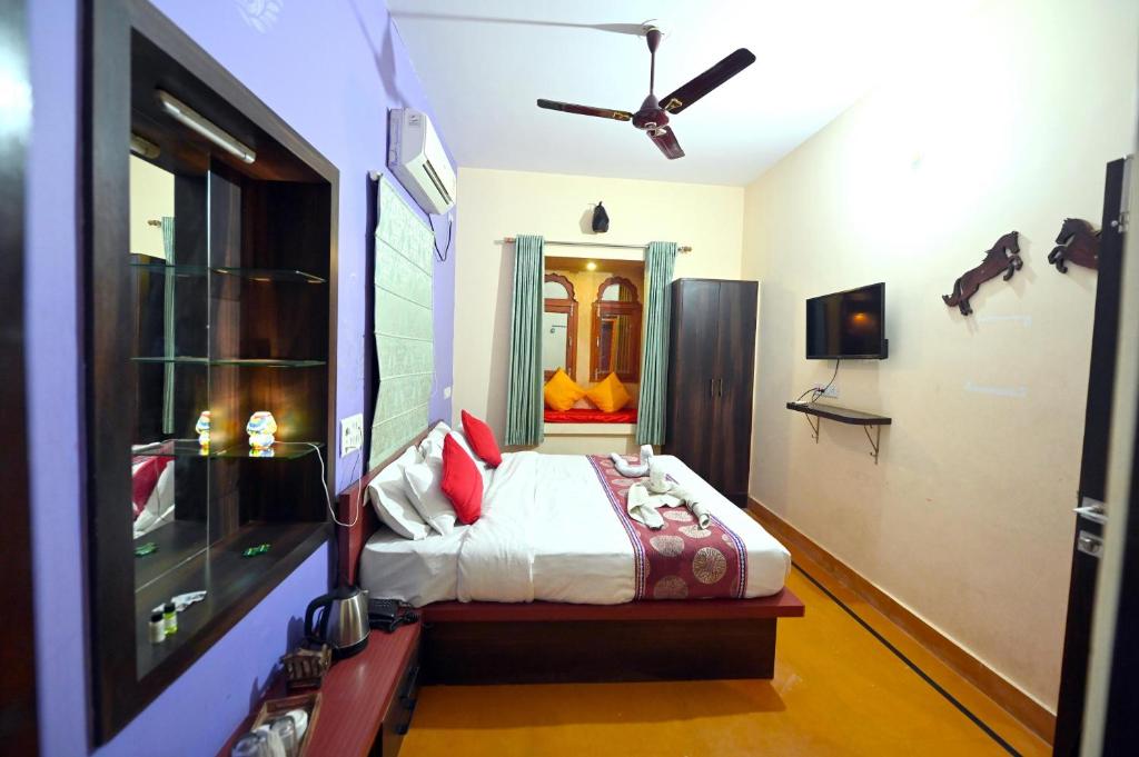 a bedroom with a bed and a ceiling fan at Chandra Safari Hotel Jaisalmer in Jaisalmer