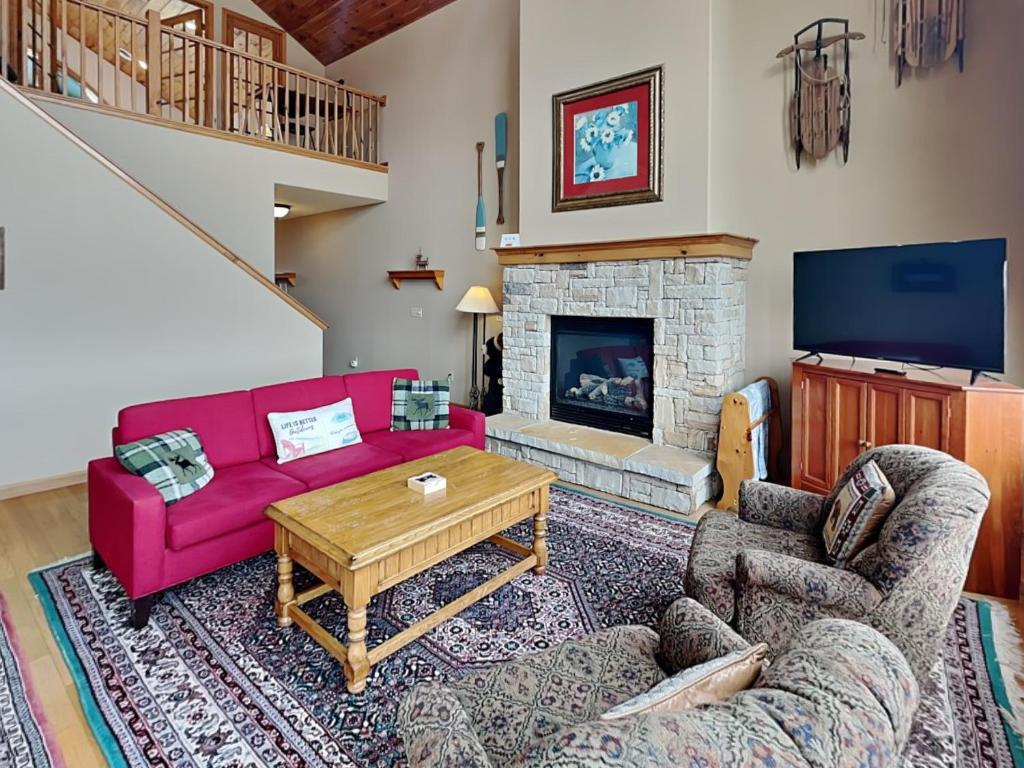 a living room with a red couch and a fireplace at Vista Emmanuel in McHenry