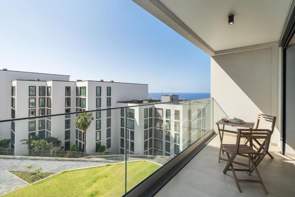a balcony with a table and chairs and a view of buildings at Acqua Residence VI by An Island Apart in Funchal