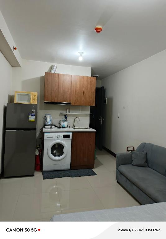 eine Küche mit einem Kühlschrank und einer Waschmaschine in der Unterkunft J and A's place in Agus