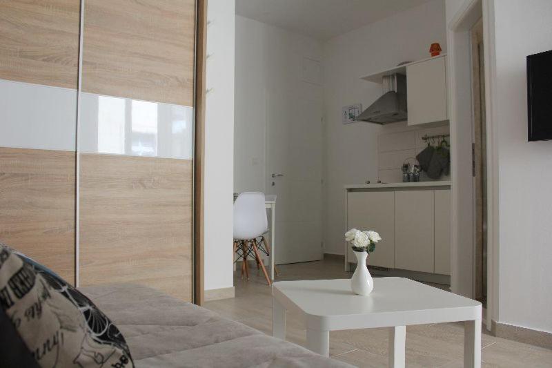 una sala de estar con un jarrón de flores sobre una mesa en Apartment Iva en Split