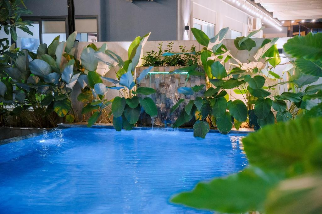 a pool of blue water in a room with plants at Hoàng Khang Hotel- Khách Sạn Buôn Ma Thuột in Buôn Kô Sir