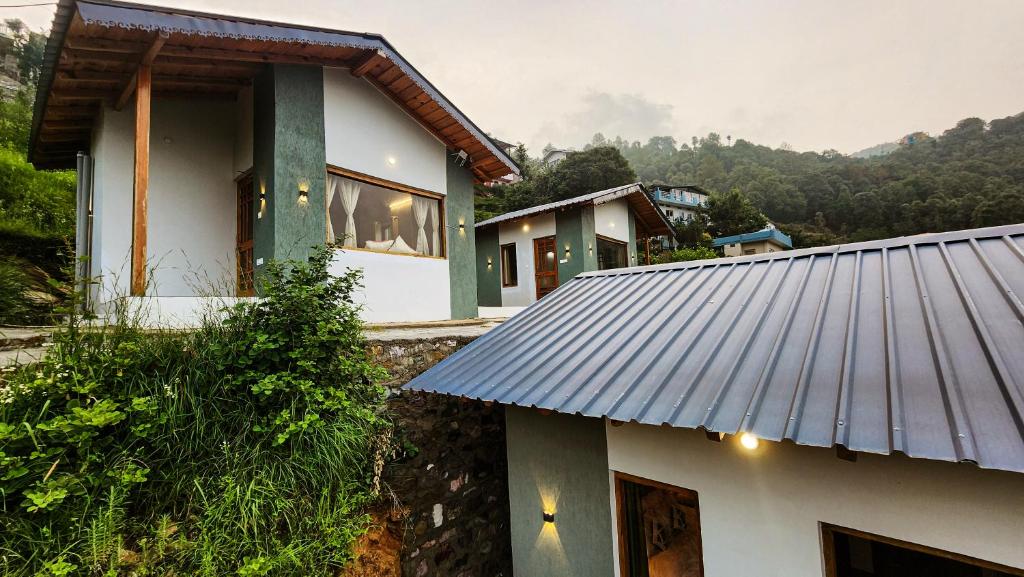 a house with a metal roof on a mountain at LiveAway Mukteshwar, Nainital by PACK in Mukteswar