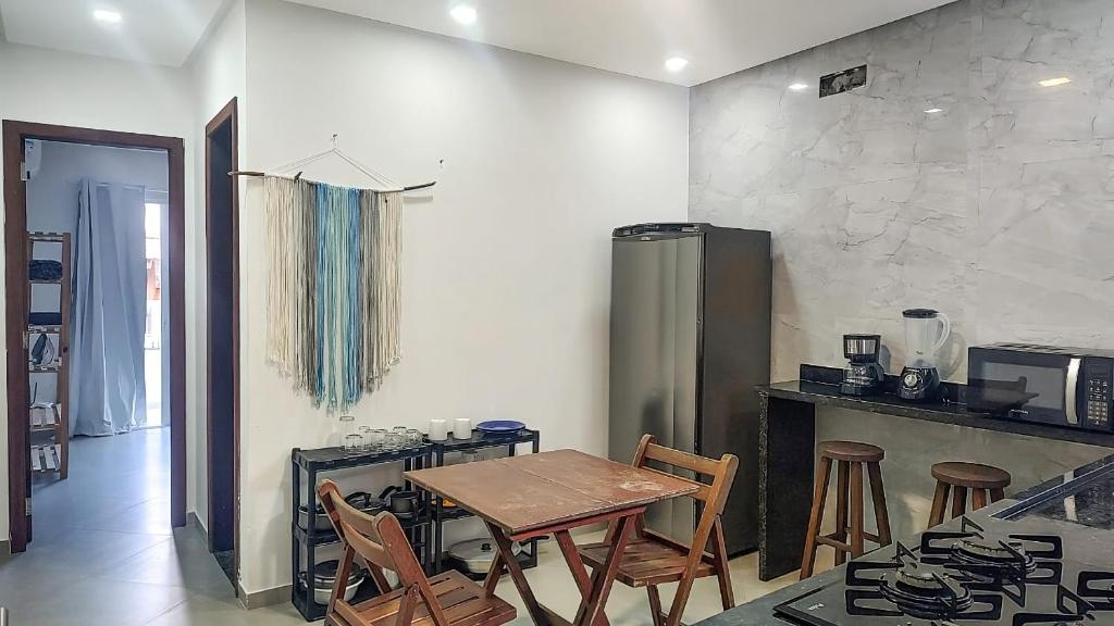 a kitchen with a table and chairs in a room at Apartamento Sol da Manhã in Morro de São Paulo