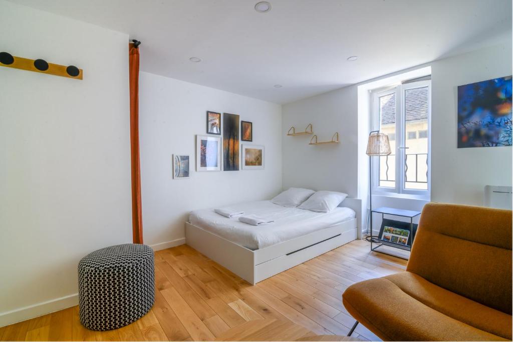 a bedroom with a bed and a chair and a window at Studio Cosy à Fontainebleau in Fontainebleau