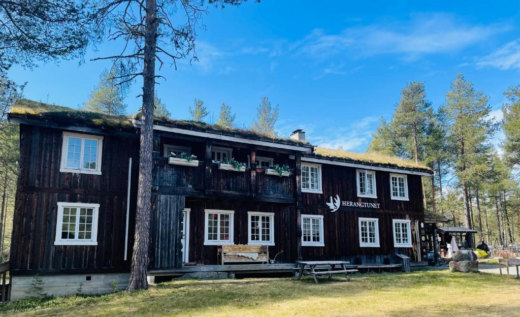 赫根尼斯Herangtunet Mountain Lodge的一座带草屋顶的古老小木屋