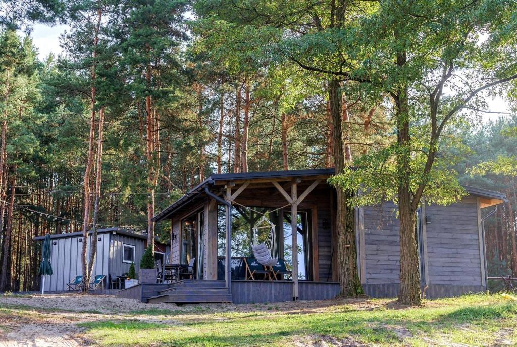 a cabin in the woods with a porch at Domki Bliżej Gwiazd in Krasnobród