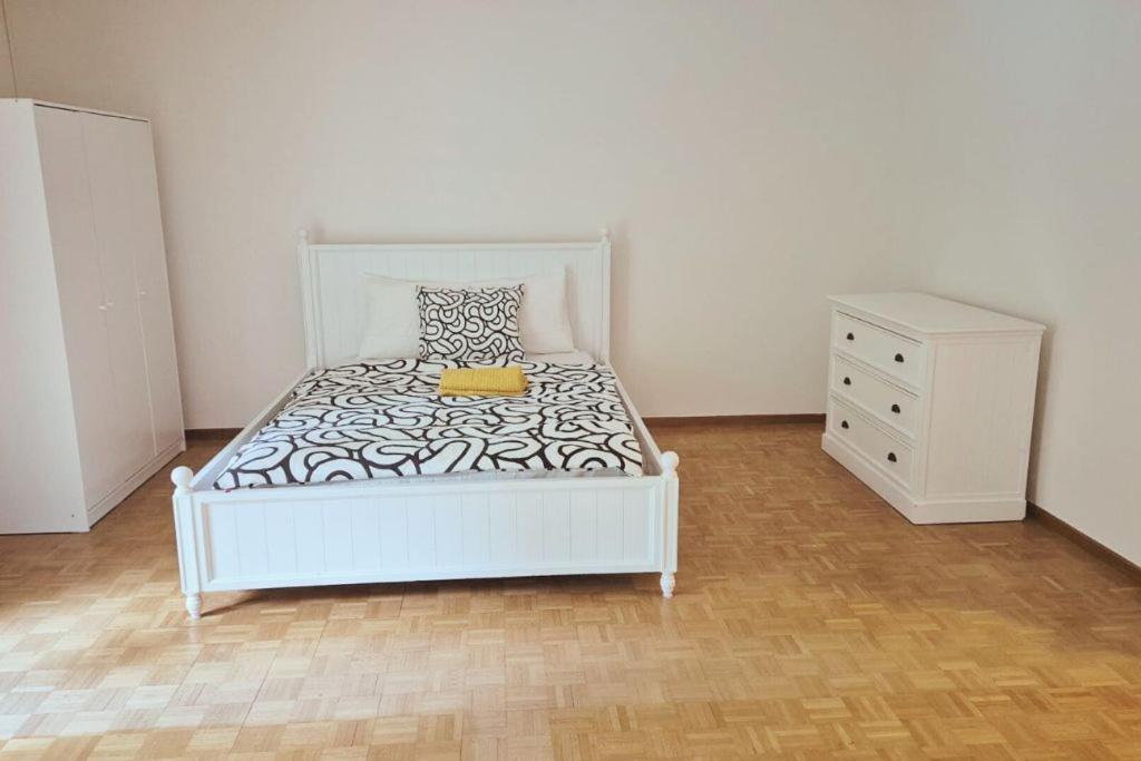 ein Schlafzimmer mit einem weißen Bett und einer Kommode in der Unterkunft City Center Flats with Balcony & Garden View Rigi - Self Checkin in Zürich