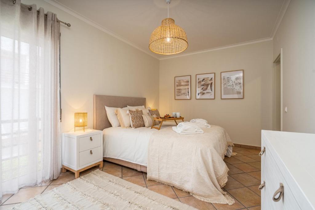a bedroom with a bed and a table and a window at Bright Flat w/ Terrace & Pools by HostWise in Tavira