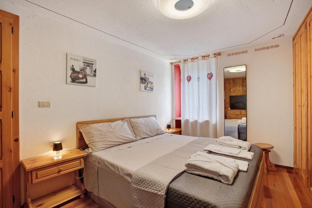 una camera da letto con un letto con asciugamani sopra di Ma Petite Maison ad Aosta